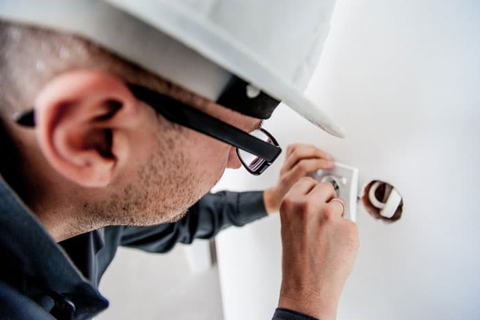 Fach-Handwerker bei Elektroarbeiten an einer Neukirch-Gewerbeimmobilie